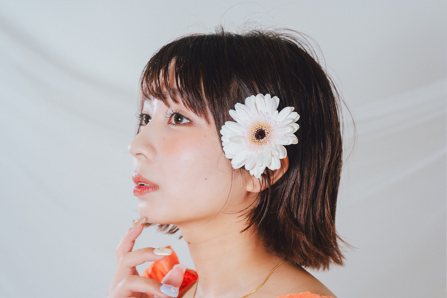 お花の髪飾りを付けた女性の横顔の画像